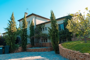 Ein zweigeschossiges Haus mit einer Steinwand und einem Garten.