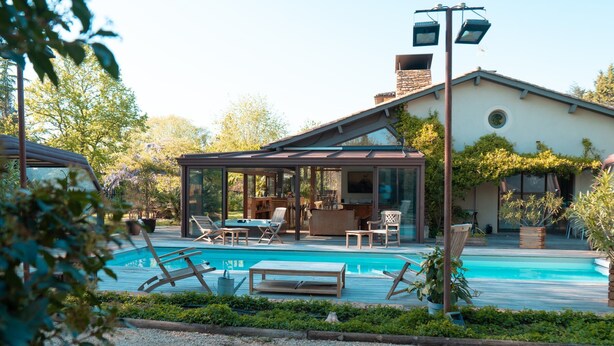 A modern house with a swimming pool, outdoor seating, and a covered patio area. - La Villa des Gones (Dommartin)