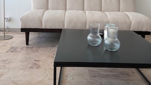 A modern living room with a sofa, a coffee table, and two glass vases.