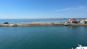 A coastal view with a beach, a pier, and buildings along the shore.