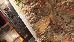A room with a wooden bed, a small wooden nightstand, and a decorative wall with plants and a star. - Taş Mahall Luxury Hotel (Sile)