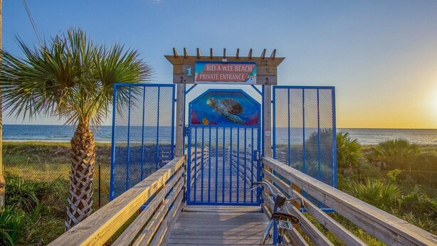 Ein hölzerner Steg führt zu einem verschlossenen Eingang mit einem Schild für den privaten Zugang zum Bid-A-Wee Beach.