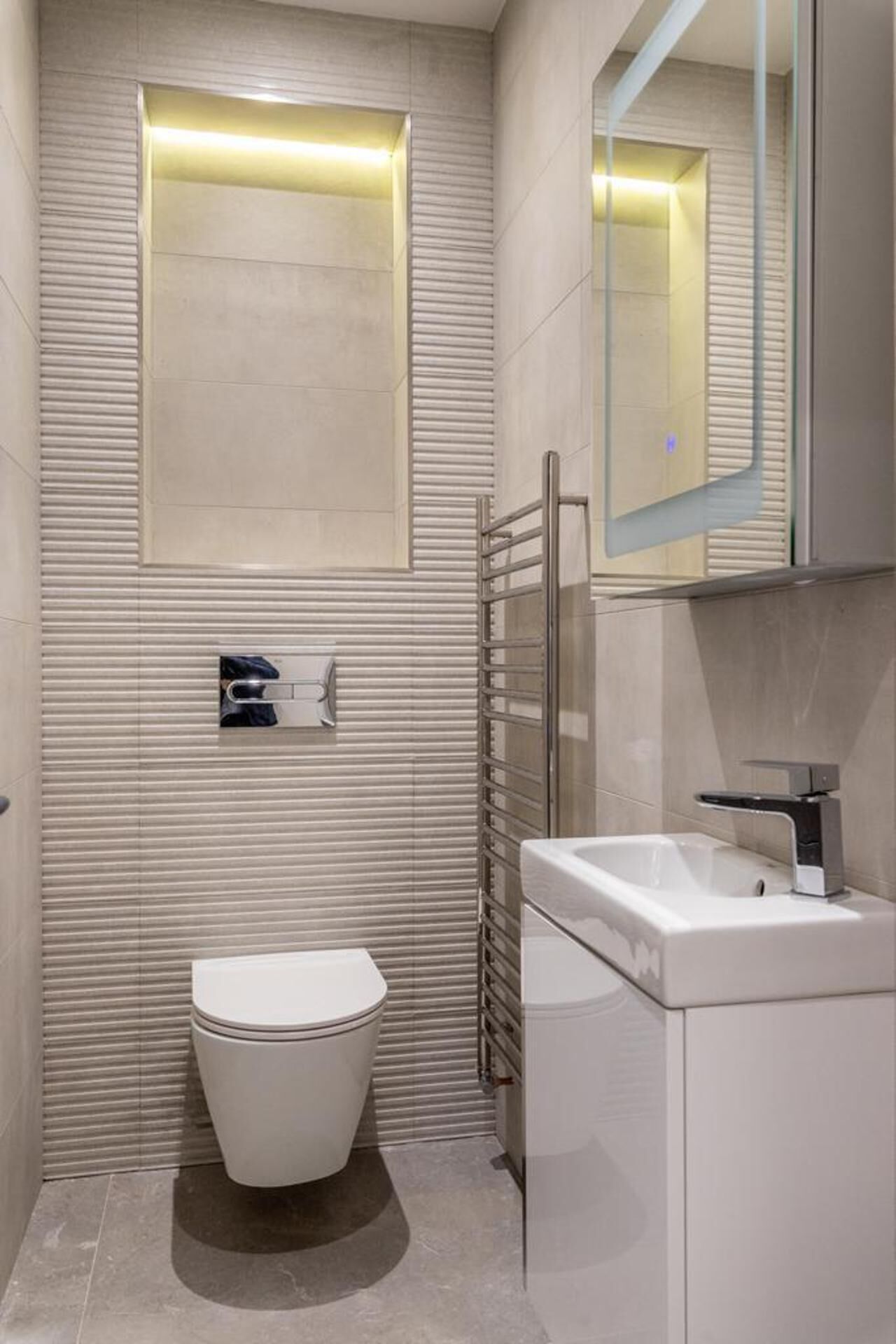 A modern bathroom with a toilet, a sink, and a mirror.