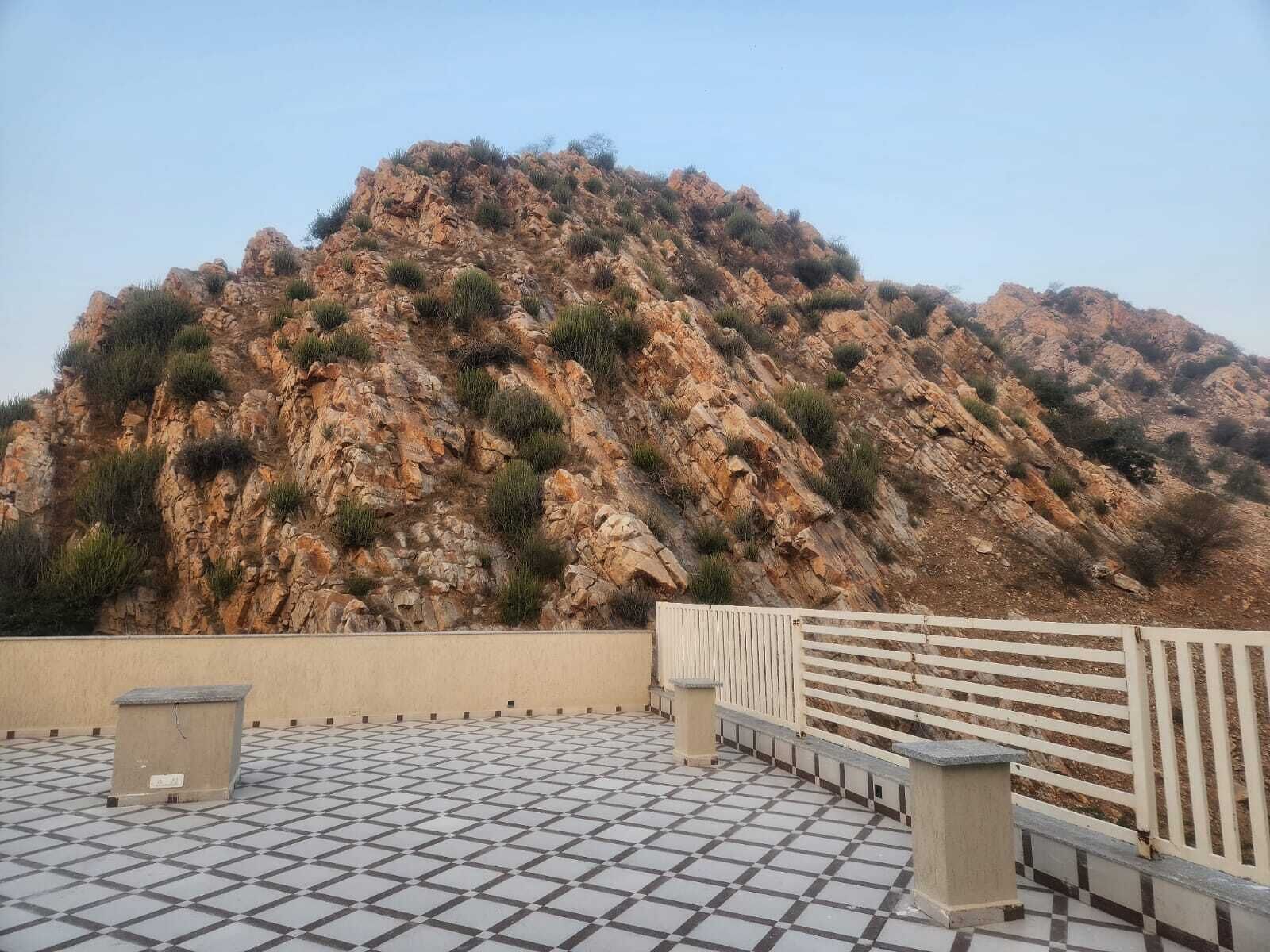 A tiled terrace with a view of a rocky mountain.