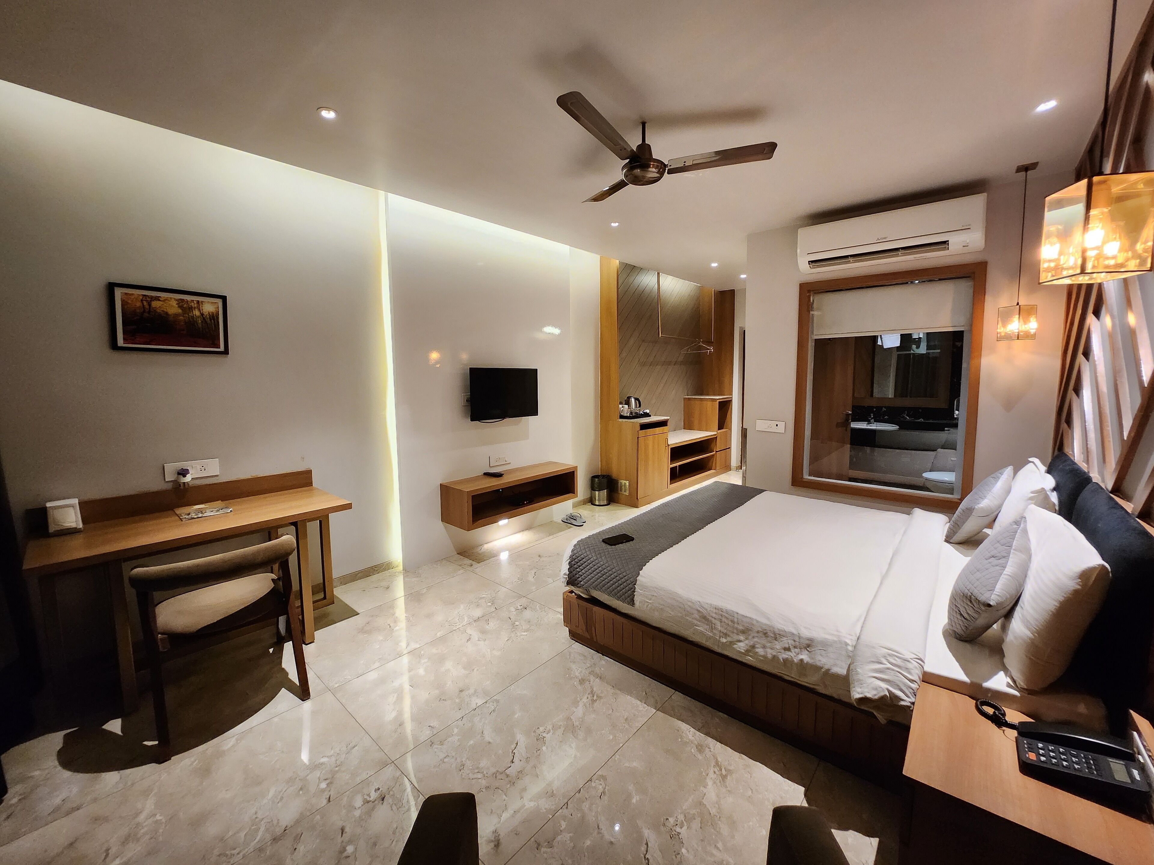 Une chambre d’hôtel moderne équipée d’un lit, d’un bureau et d’une télévision.