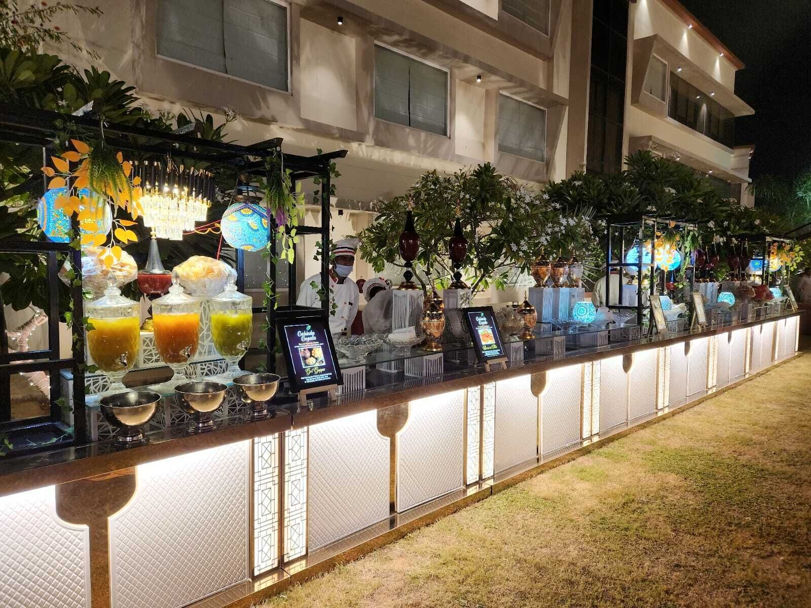 A bar area with a long counter, glassware, and various beverages.