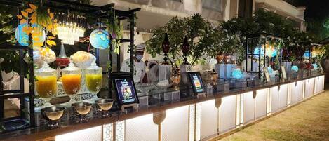 A bar area with a long counter, glassware, and various beverages.