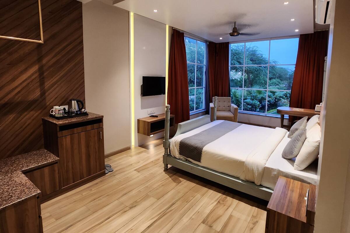 Un dormitorio moderno con una cama, mesita de noche y televisor.
