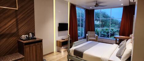A modern bedroom with a bed, bedside table, and a TV.