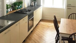A kitchen with a central island, wooden cabinets, a built-in oven, and a window with natural light.