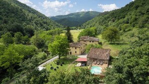 A rural villa with a swimming pool, surrounded by lush greenery and hills. - Locanda Di Alberi (Borgo San Lorenzo)