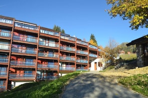 A multi-story hotel with balconies, a central courtyard, and a mountain backdrop.