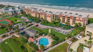 Ein Küstenhotel mit mehreren Gebäuden, einem Pool und Blick auf den Strand.