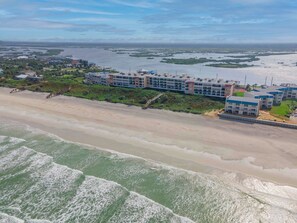 A coastal hotel with multiple buildings, a beach, and a view of the ocean.