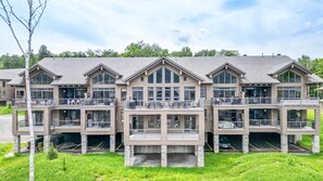 Ein mehrstöckiges Hotel mit Balkonen, großen Fenstern und einem Steinfundament.