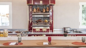 Eine Küche mit integriertem Espressomaschine, einem mit Platzsets gedecktem Esstisch und einem Fenster mit Blick auf Bäume.