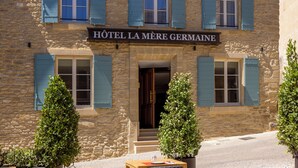 Ein Steinhaus mit einem Schild, auf dem „HOTEL LA MÈRE GERMAINE“ steht.