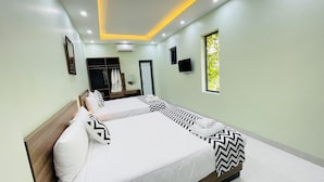 Une chambre d’hôtel moderne avec deux lits, une armoire, une télévision et une fenêtre donnant sur un paysage verdoyant.