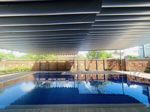 Une piscine intérieure avec un sol carrelé et un mur en briques en arrière-plan.