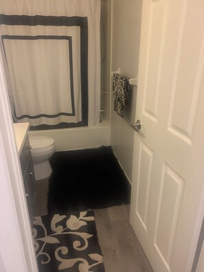 Une salle de bain avec des toilettes, une douche et une porte.