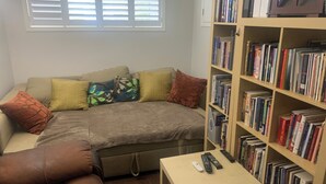 A cozy living room with a sofa, a coffee table, and a bookshelf filled with books. - Cozy Luxury in peaceful Caledonia,  13 minutes away from Hamilton Airport  (Caledonia)