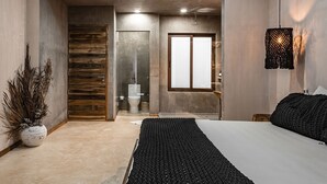A modern bedroom with a large bed, a wooden door, a toilet, and a small window. - Cozy Rooms to let (Tulum)