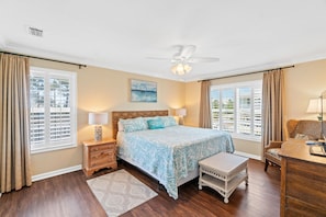 A bedroom with a bed, nightstands, a chair, and a desk.