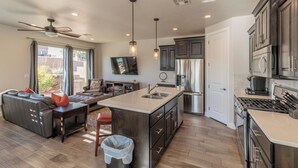 A modern kitchen with a central island, dark cabinetry, and stainless steel appliances. - Game Room w/ Arcade & PS4 - 3BR + Loft, Near Pool (St. George)