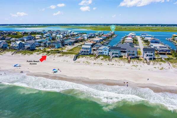 A coastal residential area with beachfront properties, a public beach access point, and a marina.