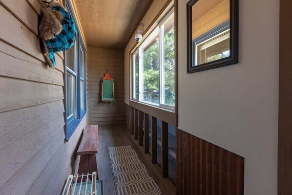 A narrow hallway with wooden walls, a bench, and a patterned rug. - Beautiful Home, Fenced Yard, AC, Pet Friendly (Pagosa Springs)