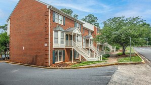 A two-story brick building with a central staircase, a covered front porch, and a small front yard. - Five Points Dawg Crib On Campus (Athens)