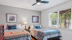 A bedroom with two beds, a ceiling fan, and a window with blinds. - Five Points Dawg Crib On Campus (Athens)
