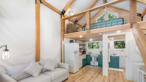 A cozy interior with a sofa, kitchenette, and wooden beams. - Tree Farm Duo - Best of the Ozarks! (Walnut Shade)