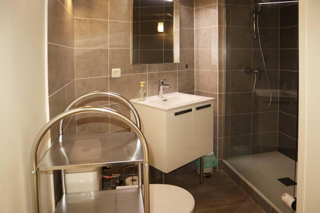 Un baño moderno con ducha, inodoro y lavamanos.