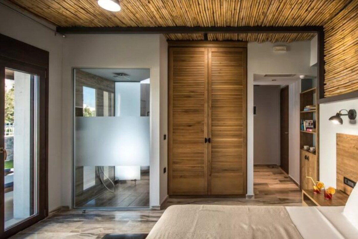 Un dormitorio moderno con una cama grande, un armario de madera y un ventanal que da a un balcón.