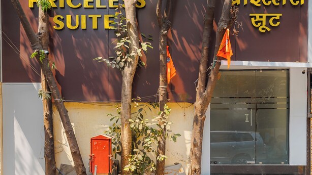 A hotel sign with the name "PRICEL'S SUITES" and a Hindi translation. - Hotel Priceless Suite (Mumbai)