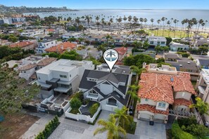Un quartier résidentiel avec des maisons modernes, une plage et des palmiers.