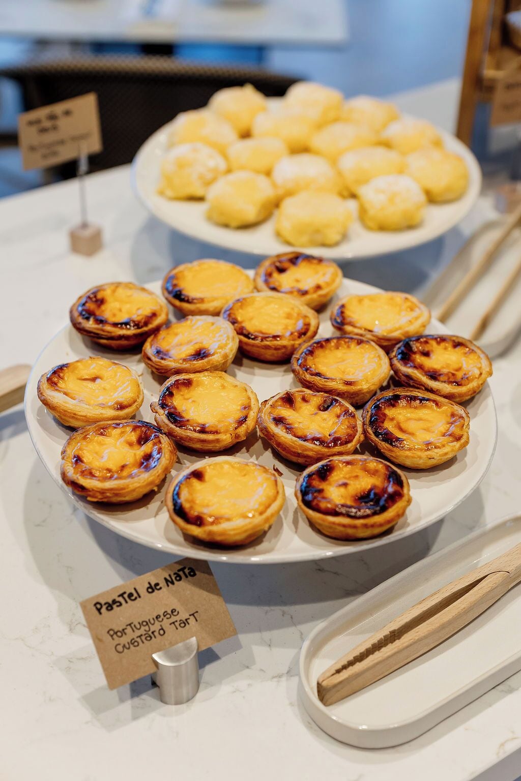 Une assiette de «pasteis de nata» sur un comptoir en marbre.
