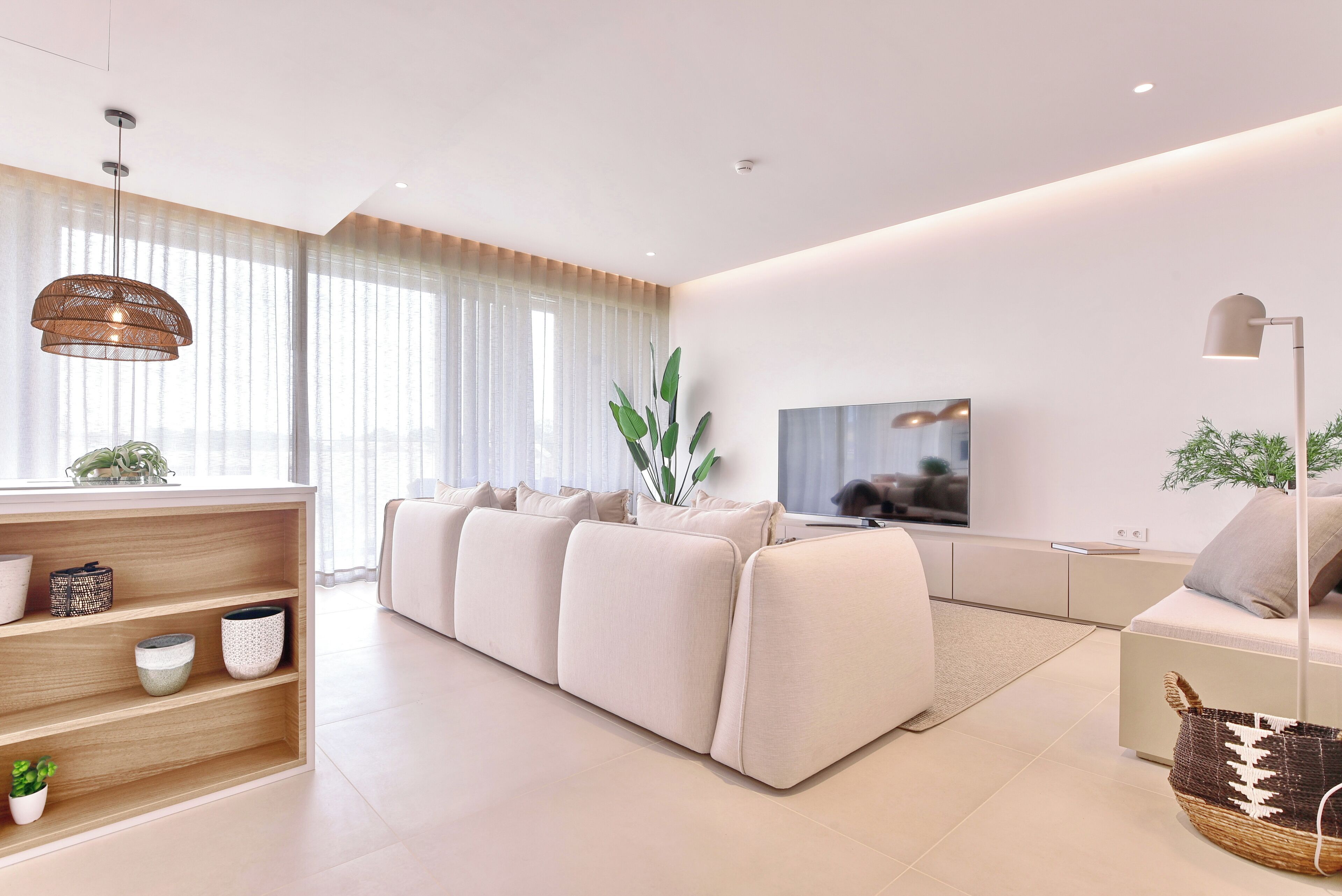 A modern living room with a sofa, a TV, and a bookshelf.