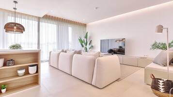 A modern living room with a sofa, a TV, and a bookshelf.