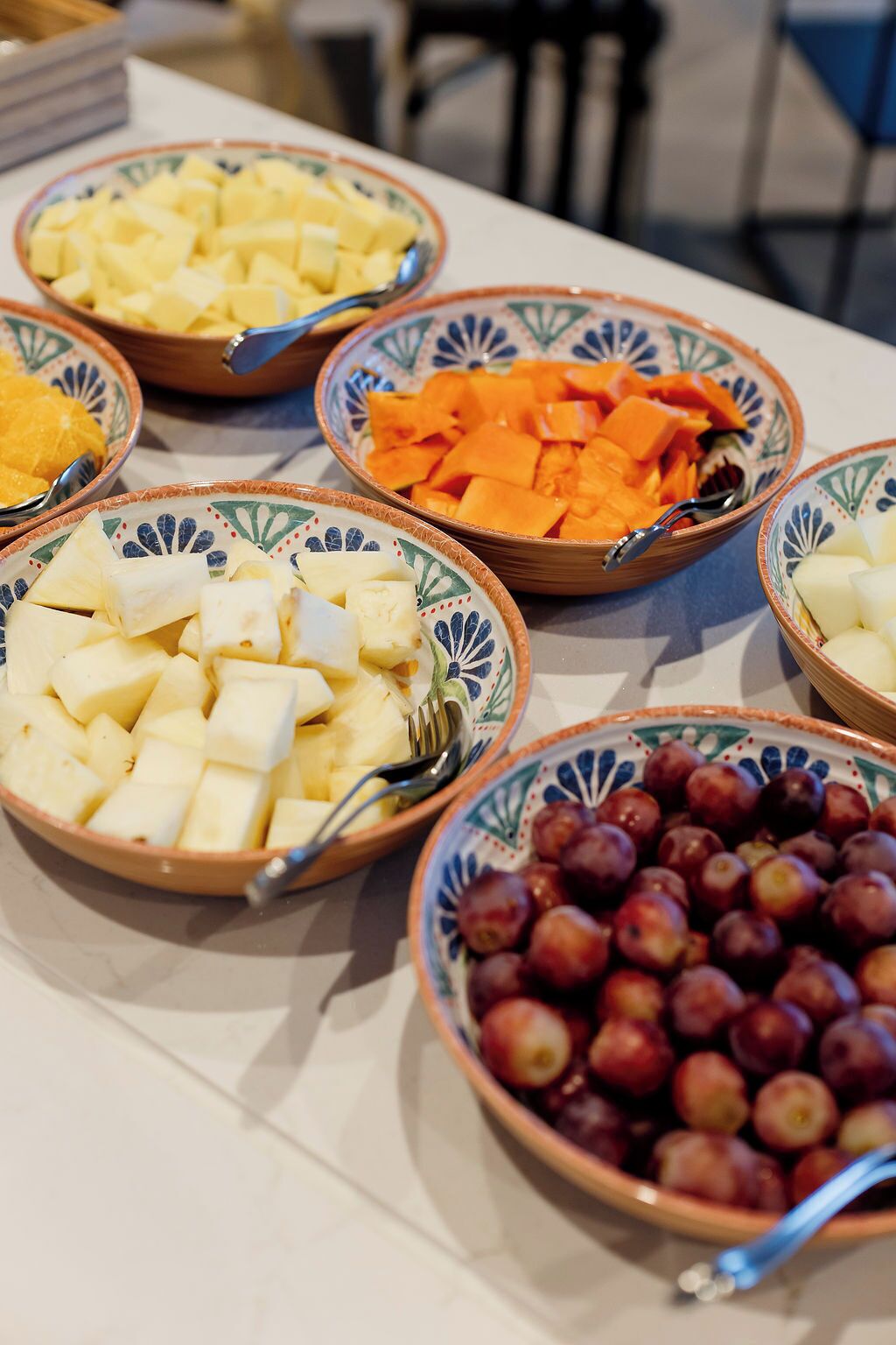 A table with bowls of various fruits and vegetables.