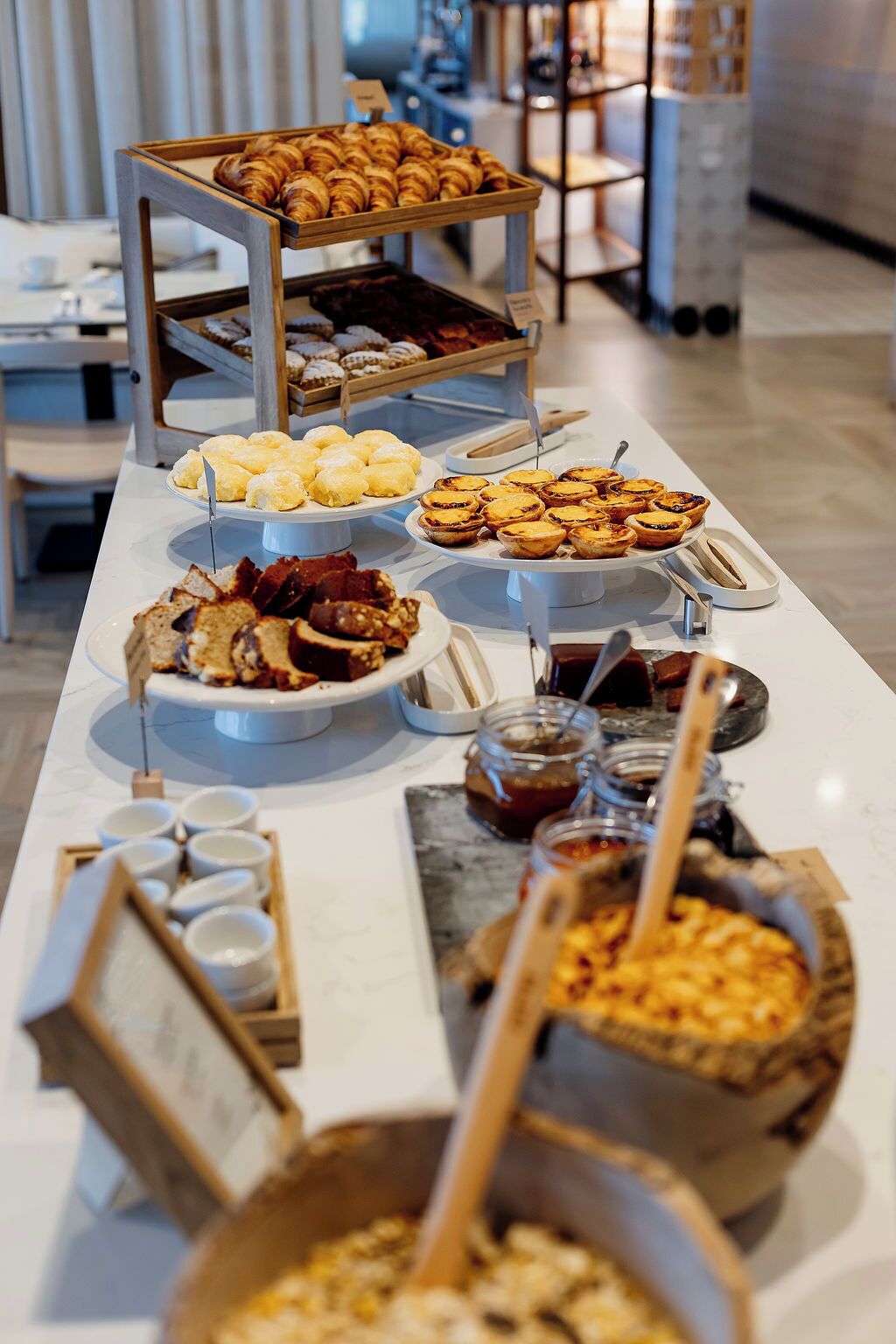 A buffet with various pastries, desserts, and condiments.