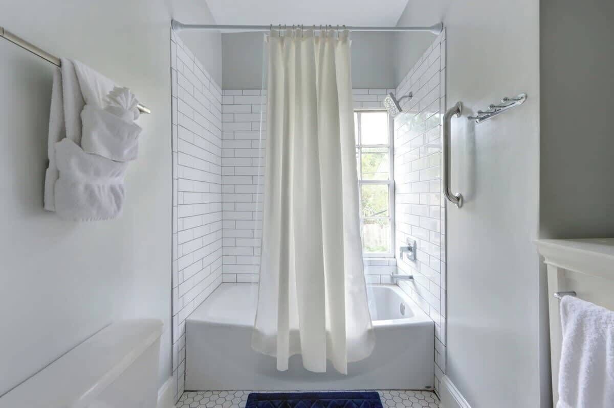 Bathtub, hair dryer, towels, shampoo