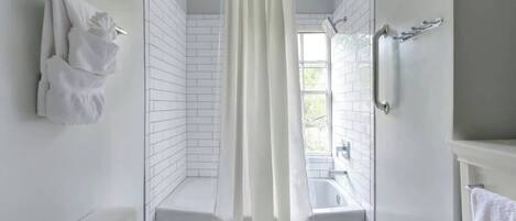 Bathtub, hair dryer, towels, shampoo