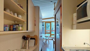 A narrow kitchen with wooden shelves, a microwave, and a sink. - 20m from ski slopes, 2nd floor, balcony, tv, 25m², Les Arcs (Les Arcs)