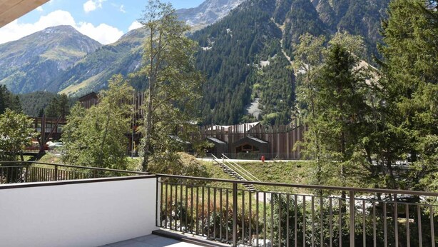 A mountain view with a wooden cabin and a modern building surrounded by trees and mountains. - 250m from ski slopes, Ground floor, terrace, parking, tv, ski locker, 47m², Pralognan-la-Vanoise (Pralognan-la-Vanoise)