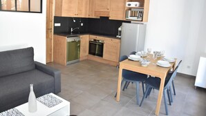 A compact kitchen with wooden cabinets, a built-in oven, and a microwave. - 250m from ski slopes, Ground floor, terrace, parking, tv, ski locker, 47m², Pralognan-la-Vanoise (Pralognan-la-Vanoise)