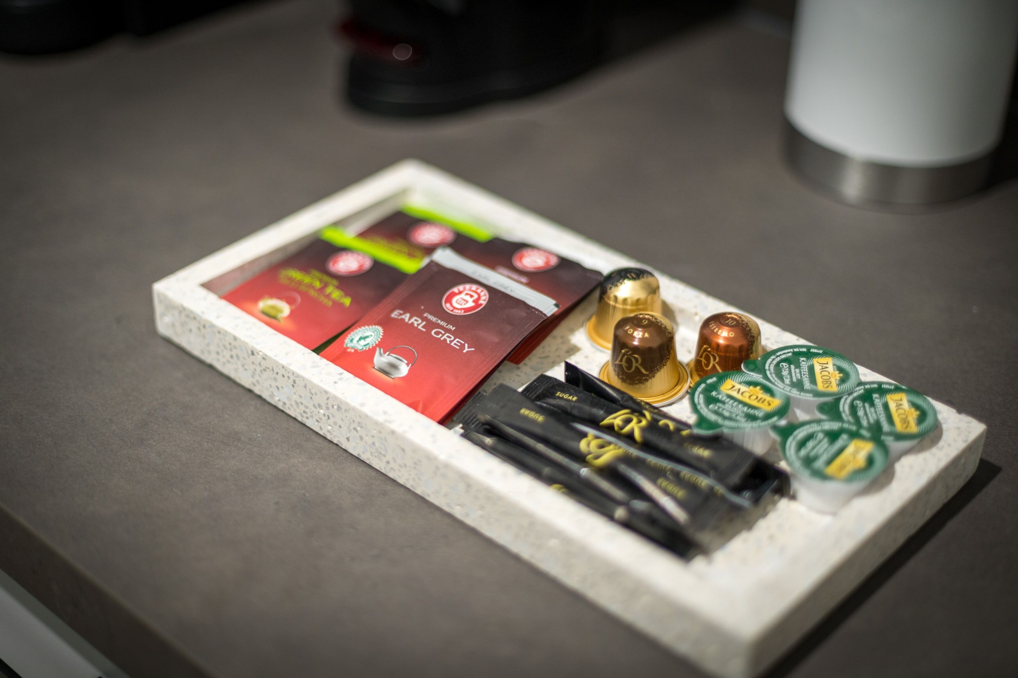 A tray with various chocolate bars and a coffee machine.