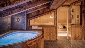 A wooden cabin interior with a hot tub, a sauna, and a visible bathroom. - Chalet, wifi, sauna, terrace, fireplace or stove, parking, tv, ski locker, 150m², Val d'Isère (Val-d'Isère)