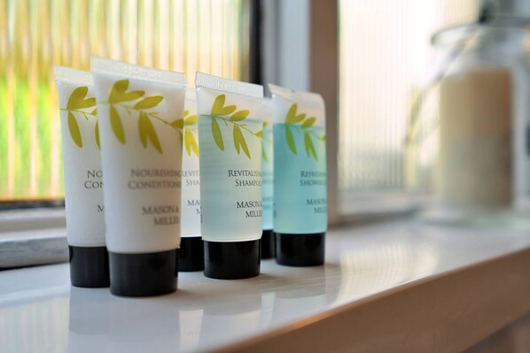 Four bottles of Nourishing Condition Shampoo and Nourishing Condition Shower on a shelf.